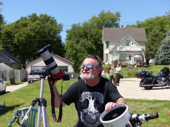 Geeky pose gritting teeth with camera and telescope